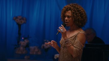 Movie still from “Jumping the Broom” (2011), directed by Salim Akil – A woman with curly hair is holding a microphone; Medium shot, Over the shoulder angle