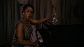 Movie still from “Jumping the Broom” (2011), directed by Salim Akil – A woman sitting at a piano in a room with curtains; Medium shot, High angle