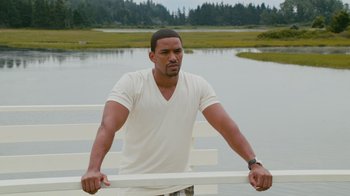 Movie still from “Jumping the Broom” (2011), directed by Salim Akil – A man standing on a bench near a body of water; Medium shot, High angle