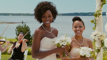 Movie still from “Jumping the Broom” (2011), directed by Salim Akil – Two women in white dresses holding flowers near water; Medium shot, Over the shoulder angle