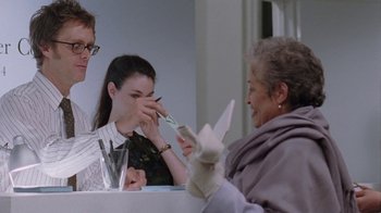 Movie still from “Junebug” (2005), directed by Phil Morrison – Two women and a man sitting at a table; Medium shot, Over the shoulder angle