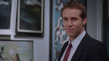 Movie still from “Junebug” (2005), directed by Phil Morrison – A man wearing a suit and tie in a room; Close Up shot, Low angle