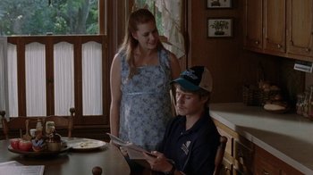 Movie still from “Junebug” (2005), directed by Phil Morrison – A man and a woman sitting at a dining room table; Medium shot, Over the shoulder angle