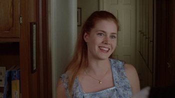 Movie still from “Junebug” (2005), directed by Phil Morrison – A young woman smiling for the camera in a room; Close Up shot, Over the shoulder angle