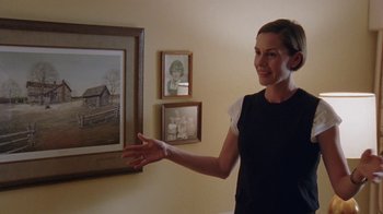 Movie still from “Junebug” (2005), directed by Phil Morrison – A woman standing in front of a picture of a house; Medium shot, Over the shoulder angle