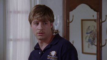 Movie still from “Junebug” (2005), directed by Phil Morrison – A man in a blue shirt standing in front of a wall; Close Up shot, Over the shoulder angle