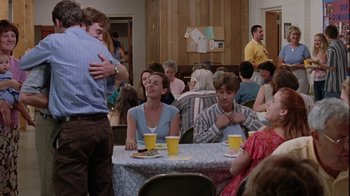 Movie still from “Junebug” (2005), directed by Phil Morrison – A group of people sitting at a table with drinks; Medium shot, Over the shoulder angle