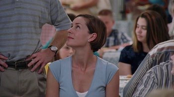 Movie still from “Junebug” (2005), directed by Phil Morrison – A person sitting in front of some people; Close Up shot, Over the shoulder angle