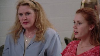 Movie still from “Junebug” (2005), directed by Phil Morrison – Two women sitting next to each other in front of a brick wall; Close Up shot, Over the shoulder angle