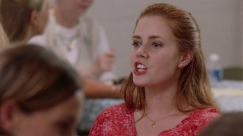Movie still from “Junebug” (2005), directed by Phil Morrison – A woman with red hair is talking to a group of people; Close Up shot, Over the shoulder angle