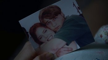 Movie still from “Junebug” (2005), directed by Phil Morrison – A person holding a picture of a boy and a girl; Extreme Close Up shot, Overhead angle