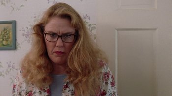 Movie still from “Junebug” (2005), directed by Phil Morrison – A person wearing glasses with long hair; Close Up shot, Low angle