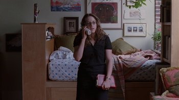 Movie still from “Junebug” (2005), directed by Phil Morrison – A woman talking on a phone in a room; Medium shot, High angle