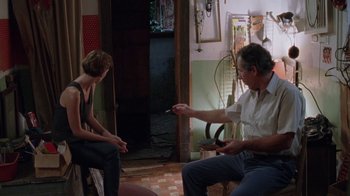 Movie still from “Junebug” (2005), directed by Phil Morrison – Two people sitting in a living room talking; Wide shot, Over the shoulder angle