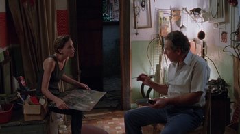 Movie still from “Junebug” (2005), directed by Phil Morrison – A woman and a man sitting in a living room talking; Medium shot, High angle