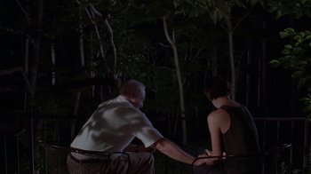 Movie still from “Junebug” (2005), directed by Phil Morrison – A man and a woman holding hands in the woods; Medium shot, High angle