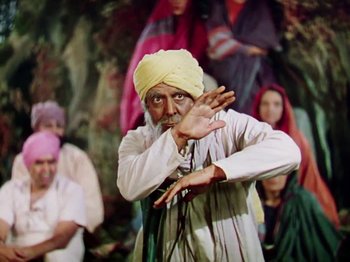 Movie still from “The Jungle Book” (1942), directed by Zoltan Korda – An old man in a turban is doing a dance; Medium shot, Low angle
