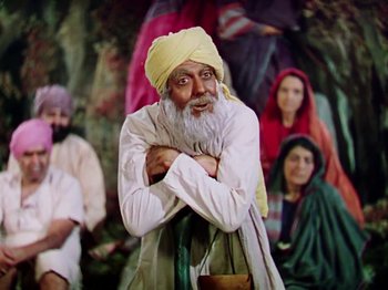 Movie still from “The Jungle Book” (1942), directed by Zoltan Korda – An old man with a beard and a yellow turban; Medium shot, High angle