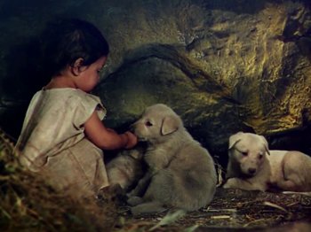 Movie still from “The Jungle Book” (1942), directed by Zoltan Korda – A little girl sitting next to a group of puppies; Medium shot, High angle