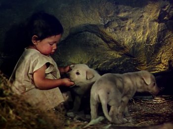 Movie still from “The Jungle Book” (1942), directed by Zoltan Korda – A little girl playing with two puppies in a cave; Medium shot, High angle
