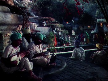Movie still from “The Jungle Book” (1942), directed by Zoltan Korda – A group of people sitting on a brick road; Wide shot, High angle