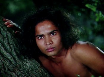 Movie still from “The Jungle Book” (1942), directed by Zoltan Korda – A man with long black hair leaning against a tree; Close Up shot, Low angle