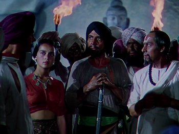 Movie still from “The Jungle Book” (1942), directed by Zoltan Korda – A group of people standing around each other with torches; Medium shot, High angle