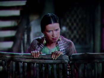 Movie still from “The Jungle Book” (1942), directed by Zoltan Korda – A young woman with long black hair leaning on a wooden fence; Medium shot, Low angle