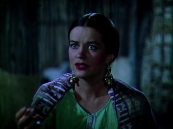 Movie still from “The Jungle Book” (1942), directed by Zoltan Korda – A woman in a green shirt and a green and black jacket; Close Up shot, Over the shoulder angle