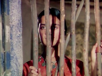 Movie still from “The Jungle Book” (1942), directed by Zoltan Korda – A woman standing behind a fence looking at the camera; Close Up shot, Overhead angle