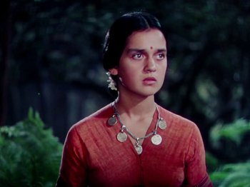 Movie still from “The Jungle Book” (1942), directed by Zoltan Korda – A woman in a red shirt is standing in a forest; Close Up shot, High angle