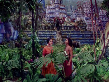 Movie still from “The Jungle Book” (1942), directed by Zoltan Korda – Two women standing next to each other in a garden; Extreme Wide shot, High angle