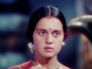 Movie still from “The Jungle Book” (1942), directed by Zoltan Korda – A young woman with a red dress and a white necklace; Close Up shot, High angle