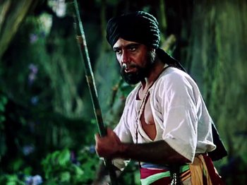 Movie still from “The Jungle Book” (1942), directed by Zoltan Korda – A man in a turban holding a stick in his hand; Medium shot, Low angle