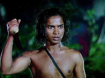 Movie still from “The Jungle Book” (1942), directed by Zoltan Korda – A shirtless man holding a sword in the woods; Medium shot, Low angle