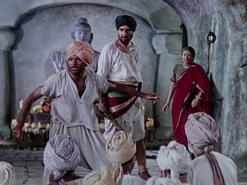 Movie still from “The Jungle Book” (1942), directed by Zoltan Korda – A group of men and a woman standing in front of a statue; Wide shot, Low angle