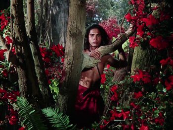 Movie still from “The Jungle Book” (1942), directed by Zoltan Korda – A man in the woods holding onto a tree branch; Wide shot, Low angle