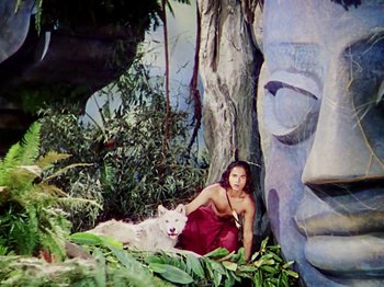 Movie still from “The Jungle Book” (1942), directed by Zoltan Korda – A woman and a white dog sitting in front of a statue; Wide shot, Low angle