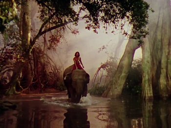 Movie still from “The Jungle Book” (1942), directed by Zoltan Korda – A woman riding on the back of an elephant through a river; Extreme Wide shot, High angle