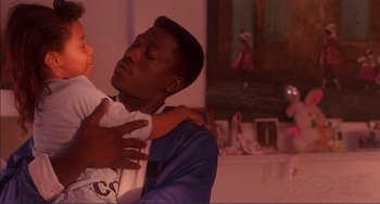 Movie still from “Jungle Fever” (1991), directed by Spike Lee – A man holding a baby in his arms; Medium shot, Over the shoulder angle