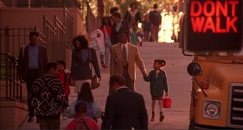 Movie still from “Jungle Fever” (1991), directed by Spike Lee – A group of people walking down a sidewalk; Wide shot, High angle