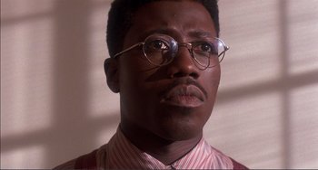Movie still from “Jungle Fever” (1991), directed by Spike Lee – A person wearing glasses and a tie; Close Up shot, Low angle
