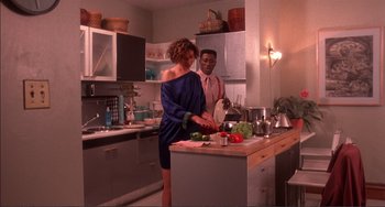 Movie still from “Jungle Fever” (1991), directed by Spike Lee – A man and a woman in the kitchen preparing a meal; Medium shot, High angle
