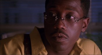 Movie still from “Jungle Fever” (1991), directed by Spike Lee – A person wearing glasses and a yellow shirt; Close Up shot, Low angle