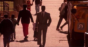 Movie still from “Jungle Fever” (1991), directed by Spike Lee – A man in a suit and tie walking down a sidewalk; Wide shot, High angle