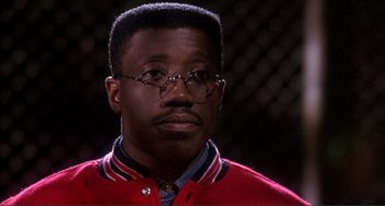Movie still from “Jungle Fever” (1991), directed by Spike Lee – A person wearing glasses and a red sweater; Close Up shot, Low angle
