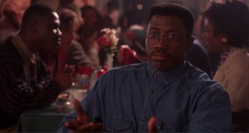 Movie still from “Jungle Fever” (1991), directed by Spike Lee – A man in a denim shirt is sitting at a table; Close Up shot, Over the shoulder angle