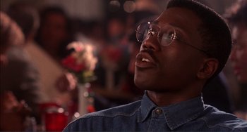 Movie still from “Jungle Fever” (1991), directed by Spike Lee – A person wearing glasses and looking up; Close Up shot, Low angle