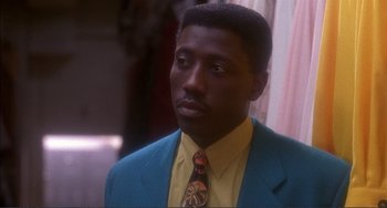 Movie still from “Jungle Fever” (1991), directed by Spike Lee – A man wearing a blue jacket and a yellow shirt; Close Up shot, High angle