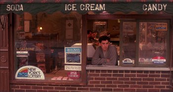 Movie still from “Jungle Fever” (1991), directed by Spike Lee – A man sitting at a window of a ice cream shop; Medium shot, High angle
